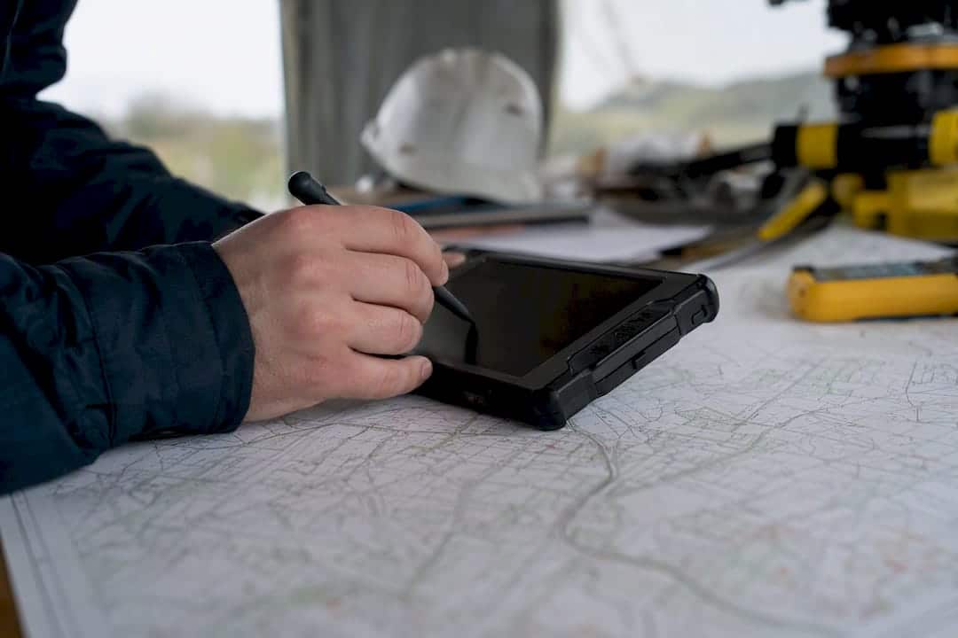 Hände, die mit GPS- und GIS-Kartendaten arbeiten